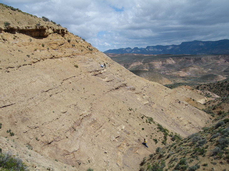 연구진들은 아르헨티나 남부에 있는 Lefipan 층의 절벽옆면에서 화석을 수집하고 있다. 절벽 중간에 찍힌 과학자들은 백악기 말기 층을 조사하고 있다. 반면, 그 위에 절벽에서 튀어나온 사암으로 된 바위는 고제3기의 시작을 나타낸다. 출처: University of Pennsylvania/ PETER WILF